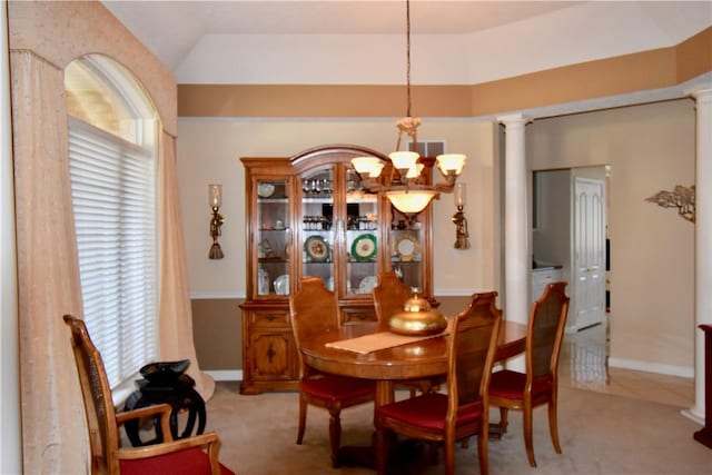 carpeted dining space with ornate columns and a notable chandelier