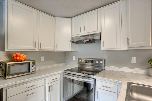 kitchen featuring appliances with stainless steel finishes, sink, white cabinets, and light stone counters