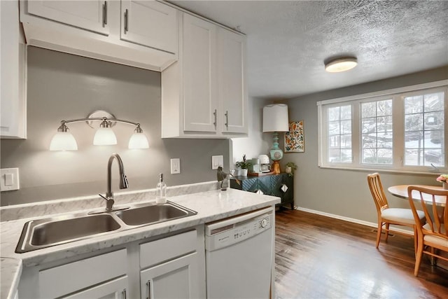 kitchen featuring dishwasher, sink, hardwood / wood-style floors, and white cabinets