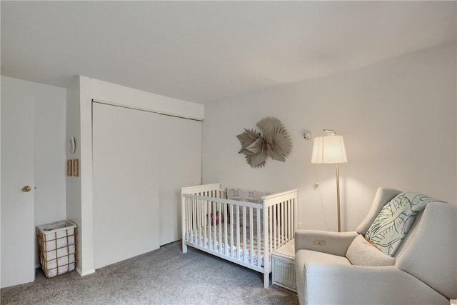 carpeted bedroom with a crib and a closet