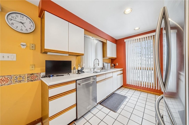 kitchen featuring light tile patterned flooring, stainless steel appliances, sink, and white cabinets