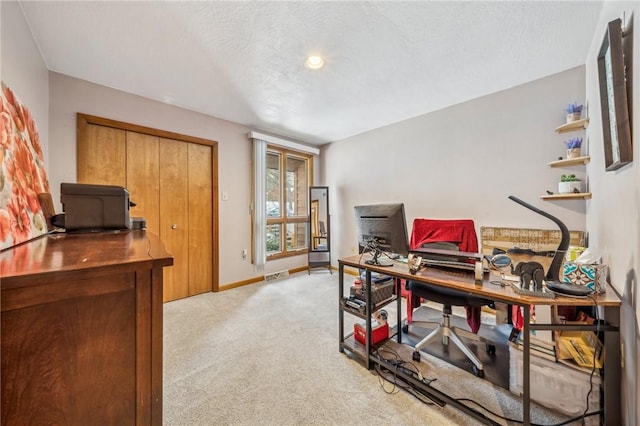 carpeted home office with a textured ceiling