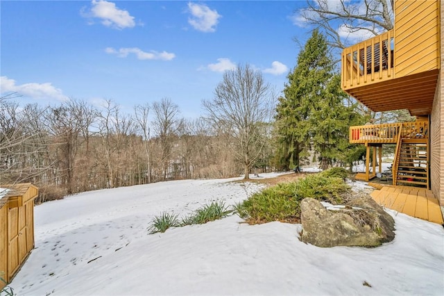 yard covered in snow featuring a deck