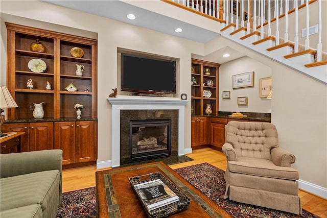 living room with a fireplace and light wood-type flooring