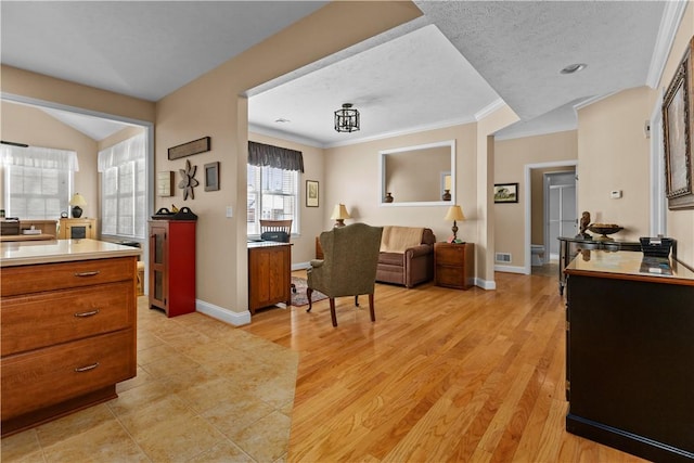 interior space featuring crown molding, a textured ceiling, and light wood-type flooring