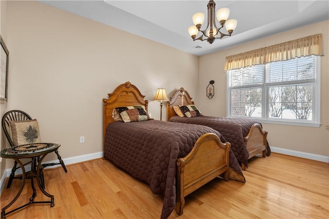 bedroom featuring light hardwood / wood-style flooring and a chandelier