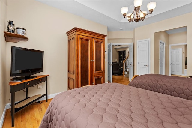 bedroom with an inviting chandelier and light hardwood / wood-style flooring