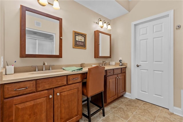 bathroom with tile patterned flooring, vanity, and walk in shower