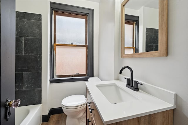 bathroom with vanity, hardwood / wood-style floors, plenty of natural light, and toilet