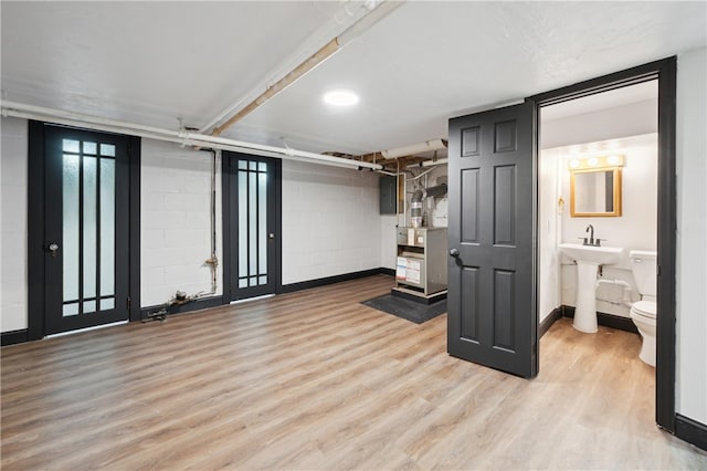 basement with sink, electric panel, and light hardwood / wood-style floors