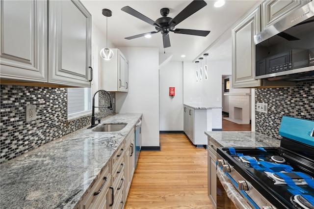 kitchen featuring pendant lighting, sink, light hardwood / wood-style floors, and appliances with stainless steel finishes