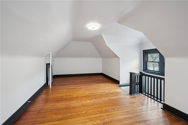 additional living space featuring hardwood / wood-style flooring and lofted ceiling