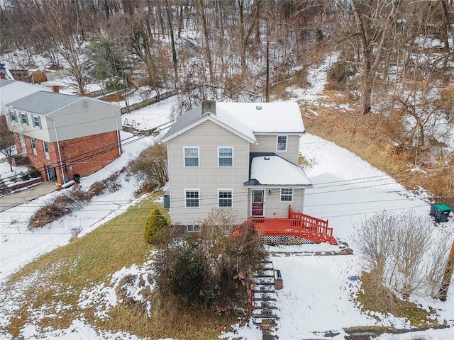 snow covered house featuring a wooden deck