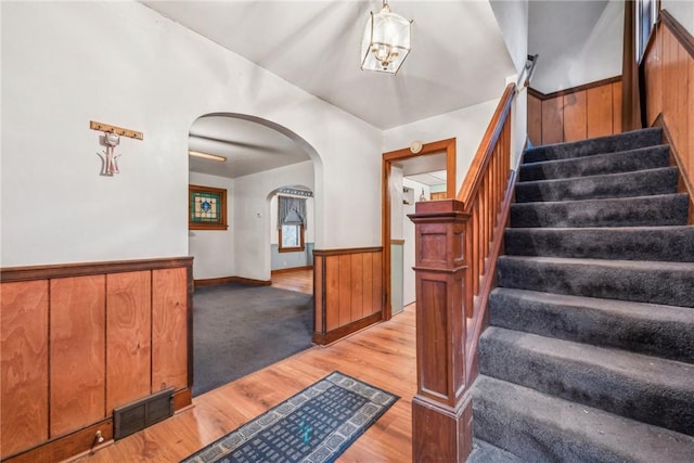 stairway with hardwood / wood-style flooring and wooden walls