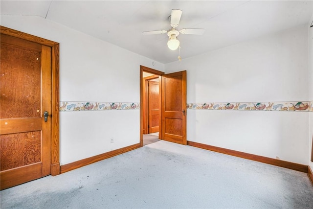 carpeted spare room featuring lofted ceiling and ceiling fan