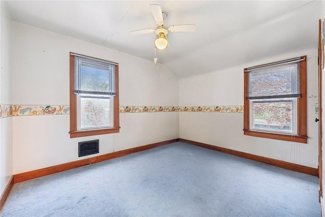 carpeted spare room with vaulted ceiling, plenty of natural light, and ceiling fan