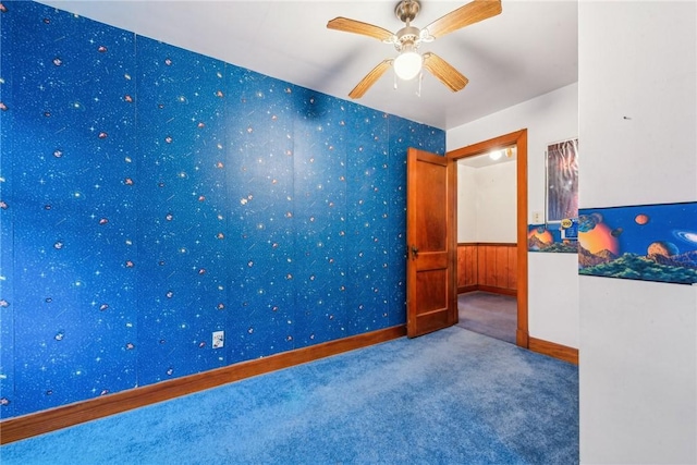 spare room featuring ceiling fan and carpet