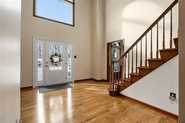 entrance foyer with light hardwood / wood-style flooring and a high ceiling