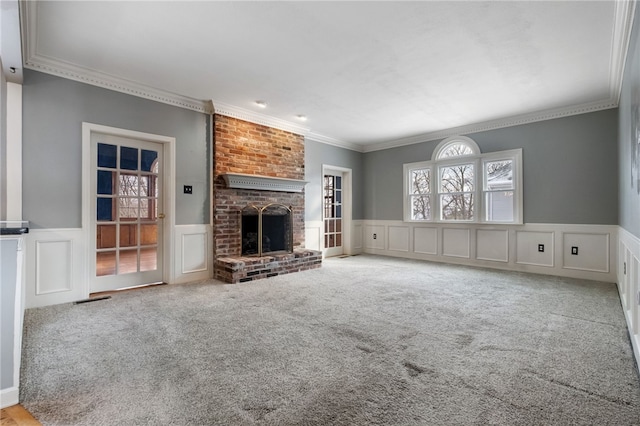 unfurnished living room with carpet flooring, ornamental molding, and a fireplace