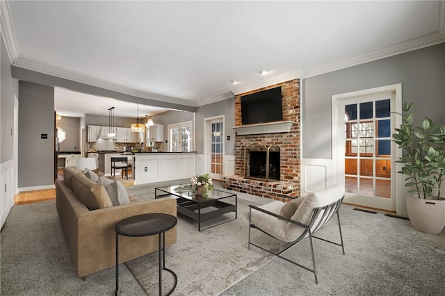 living room with crown molding and a fireplace