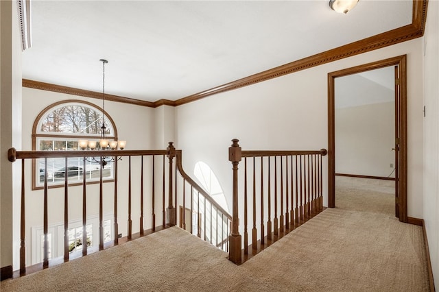 hallway featuring ornamental molding, carpet floors, and a notable chandelier