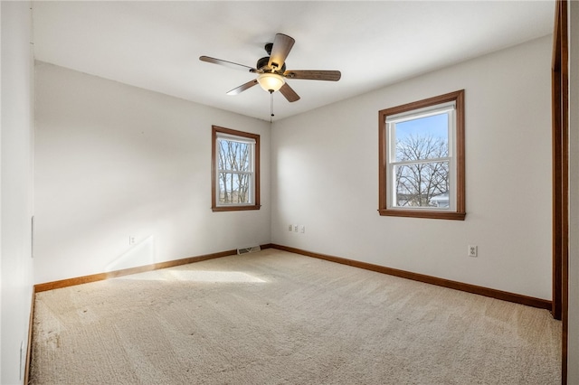 carpeted spare room with ceiling fan