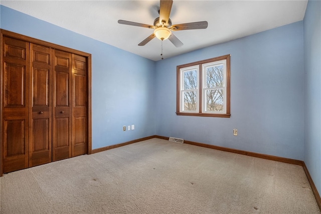 unfurnished bedroom with ceiling fan, carpet floors, and a closet