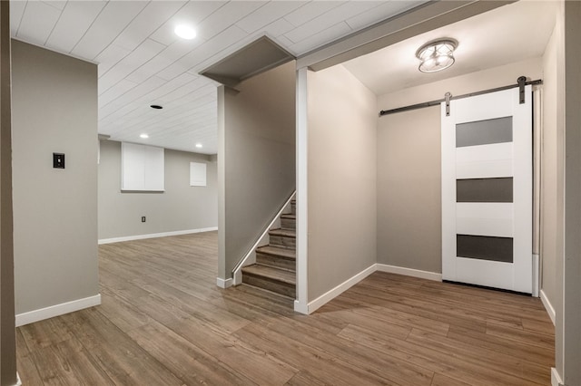 foyer entrance featuring a barn door and light hardwood / wood-style flooring