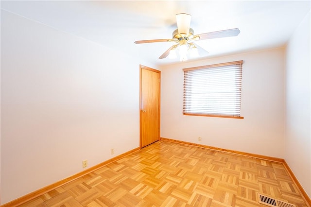 unfurnished room with ceiling fan and light parquet flooring