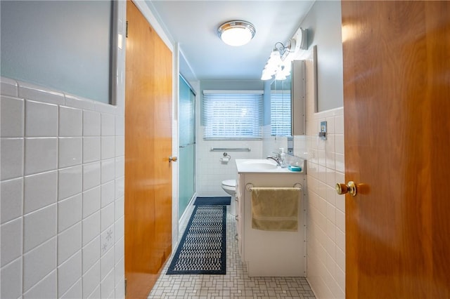 bathroom featuring vanity, toilet, tile patterned flooring, and tile walls