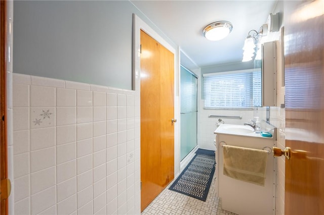 bathroom with vanity, tile walls, tile patterned floors, and a shower with shower door