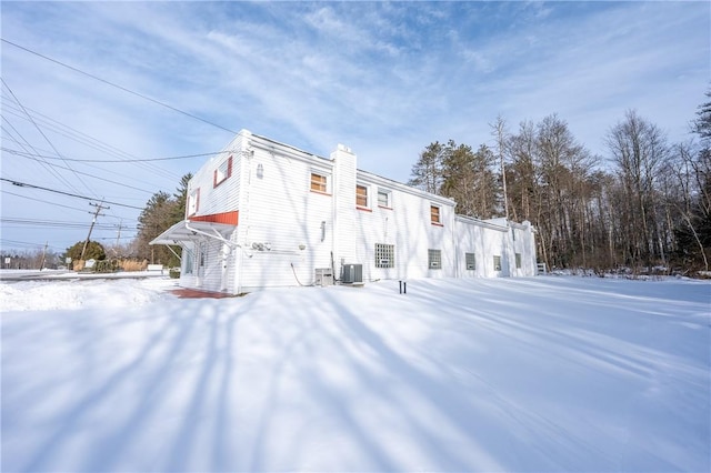 snow covered property with central air condition unit