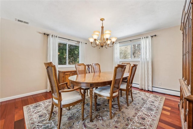 dining room with a baseboard heating unit, dark hardwood / wood-style floors, and a notable chandelier