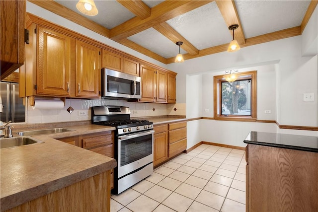 kitchen with beamed ceiling, light tile patterned floors, appliances with stainless steel finishes, pendant lighting, and backsplash