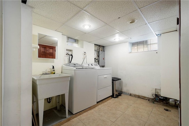 clothes washing area featuring light tile patterned floors, washing machine and dryer, and electric panel