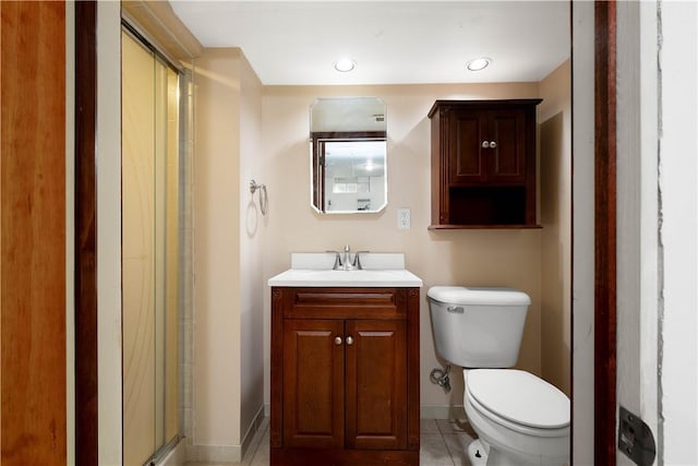 bathroom featuring tile patterned floors, vanity, toilet, and an enclosed shower