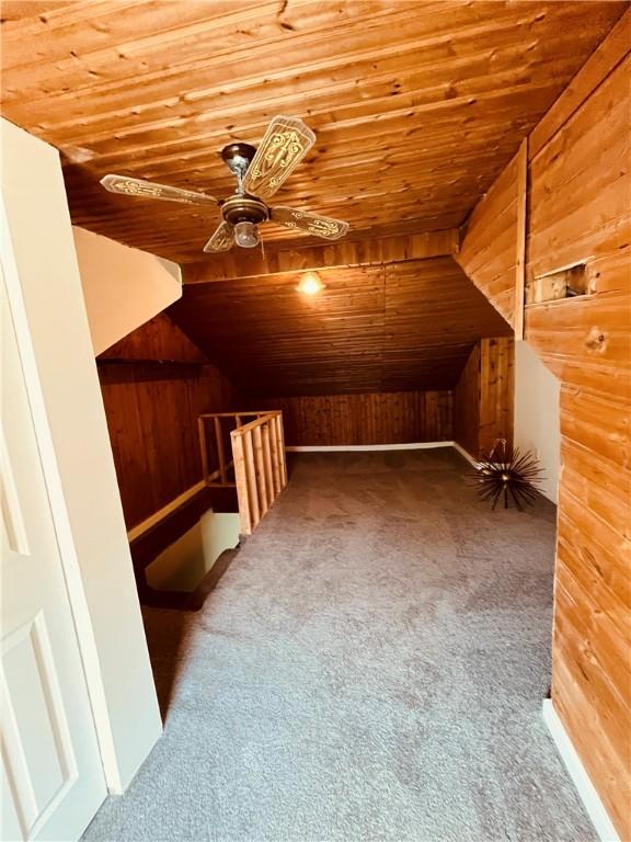 additional living space featuring wood ceiling, carpet flooring, and wooden walls