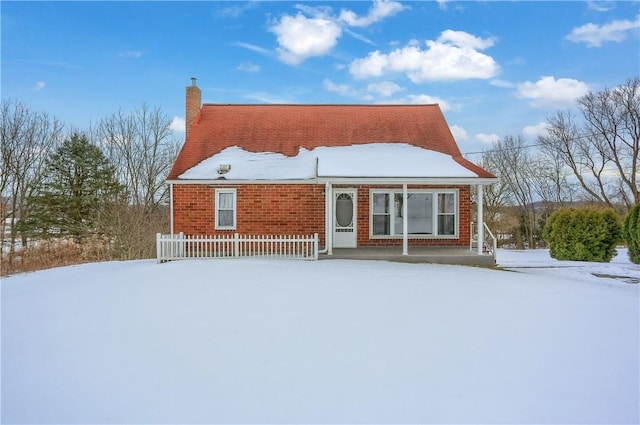 view of snow covered rear of property