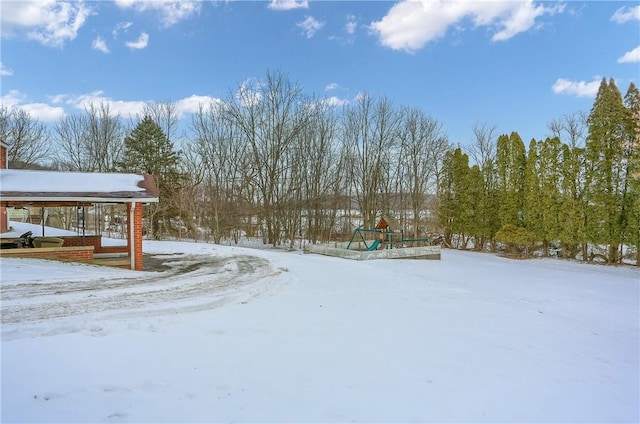 snowy yard featuring a playground