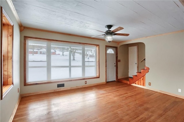 empty room with ornamental molding, ceiling fan, and light wood-type flooring