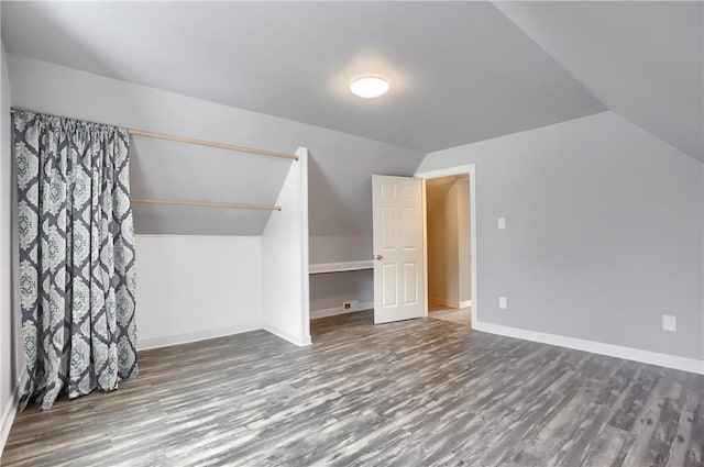 additional living space with hardwood / wood-style flooring and lofted ceiling