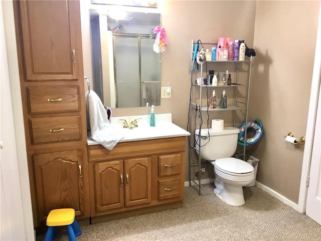 bathroom with an enclosed shower, vanity, and toilet