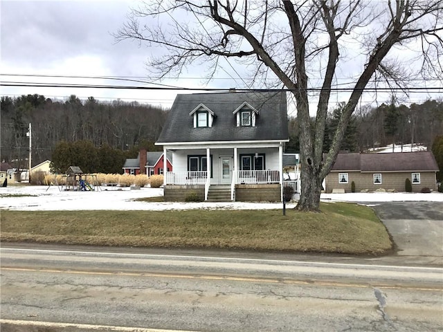 cape cod-style house with a front yard and covered porch