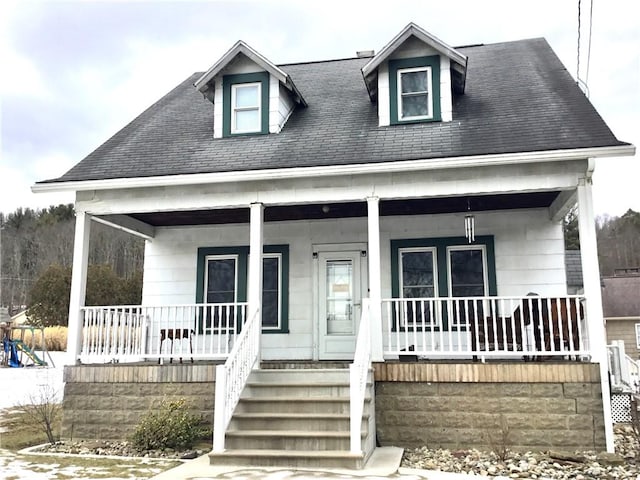 cape cod house featuring covered porch