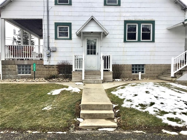 entrance to property featuring a lawn