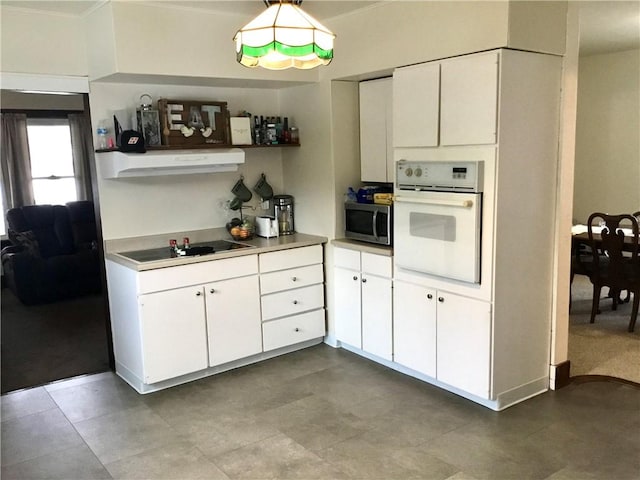 kitchen featuring white cabinets, oven, and black electric cooktop