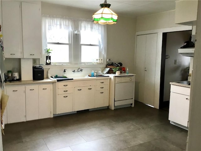 kitchen with decorative light fixtures, dishwasher, sink, dark tile patterned flooring, and white cabinets