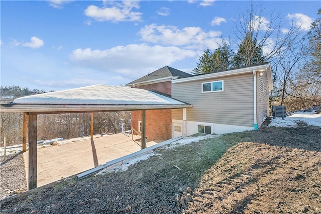 snow covered property with central air condition unit