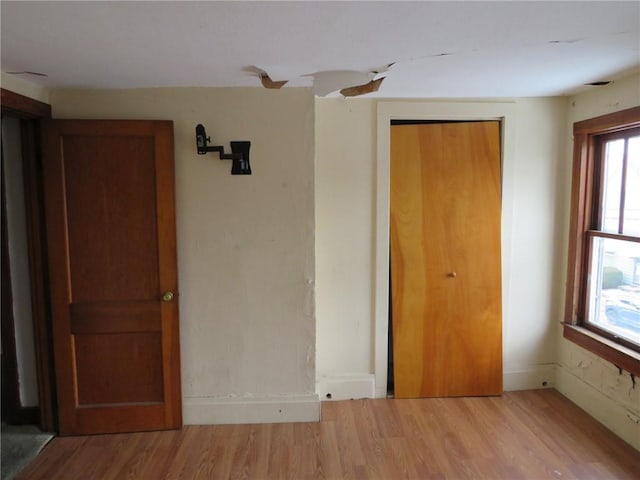 unfurnished bedroom featuring wood-type flooring and a closet