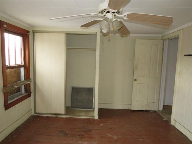 unfurnished bedroom with crown molding, a ceiling fan, a closet, and wood-type flooring